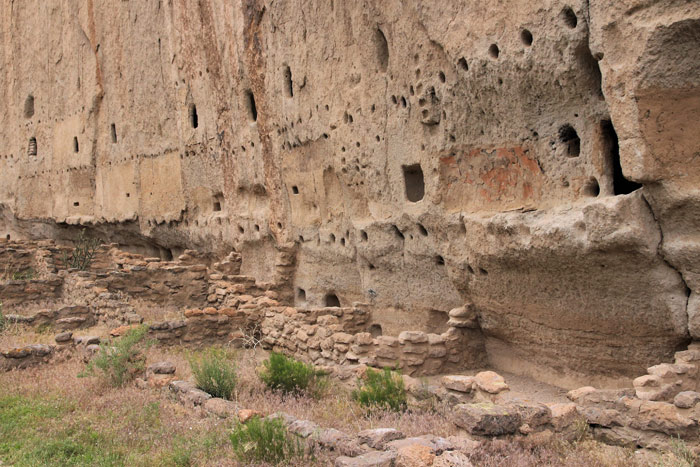 Long House in Bandelier National Monument - crumbling walls of former structures built just in front of the cliff, with original beam holes still visible.