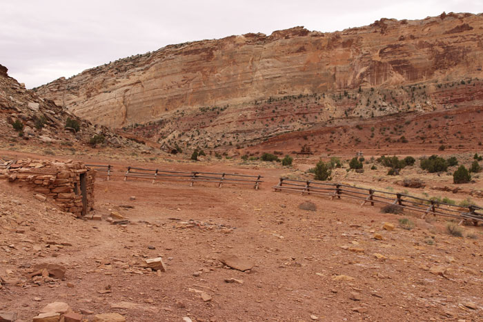 Temple Mountain Mining District in the San Rafael Swell, Utah - a fenced-in stone structure, and a view of the campground. 
