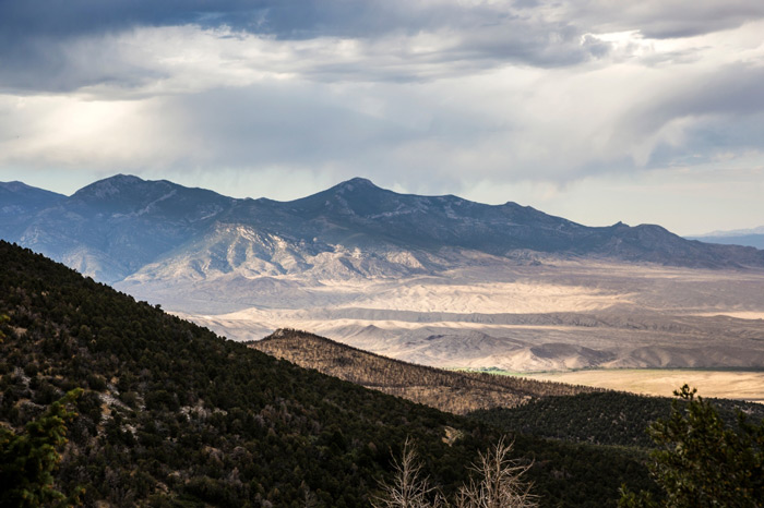 View of Great Basin National Park with desert valleys, wooded hills, and massive rugged snow-covered mountains in the background, featuring the second tallest peak in Nevada - Wheeler Peak.
