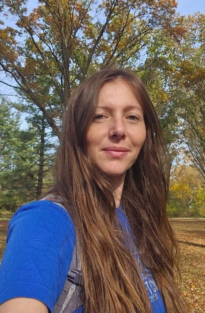 Picture of a Discover All Corners Mom - fall scenery, sunny day with golden leaves, smiling into the camera