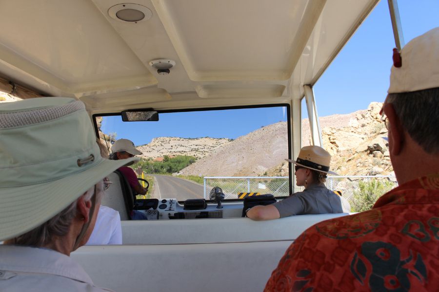 Visitors sitting inside the Dinosaur National Monument shuttle near the gate that leads up the road to the Quarry Exhibit Hall.
