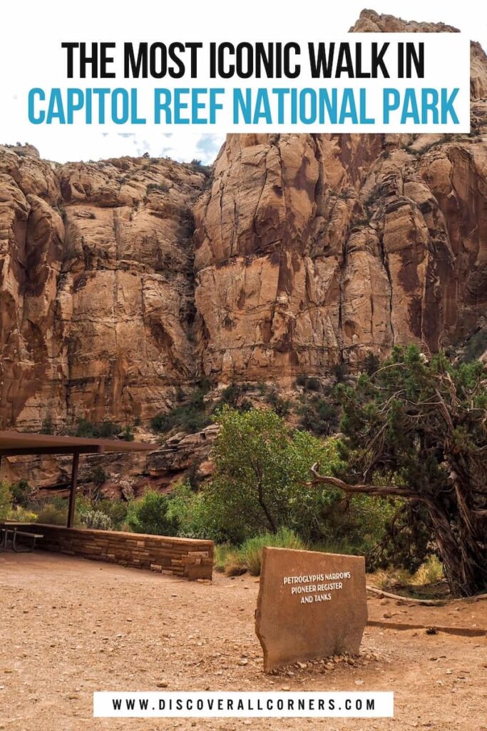 Trailhead of the Capitol Gorge Trail in Capitol Reef National Park with the park sign, tall canyon walls, desert vegetation, and part of the shaded picnic area. Text overlay - The most iconic walk in Capitol Reef National Park.