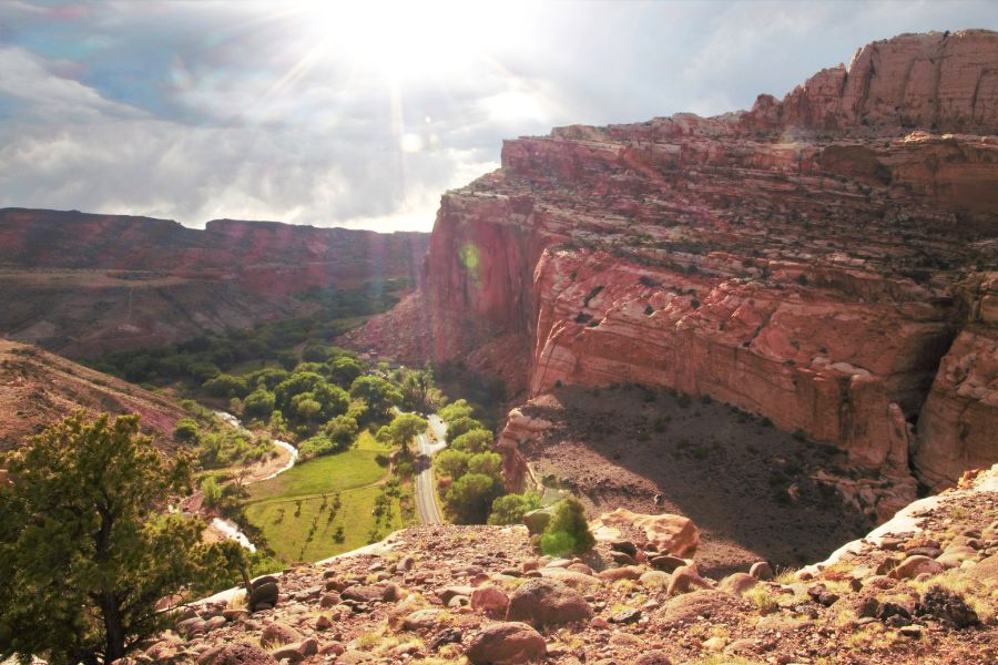 View of Fruita Valley and the towering cliffs of Capitol Reef National Park from the Fruita Overlook, with storm clouds starting to build above the colorful landscape.