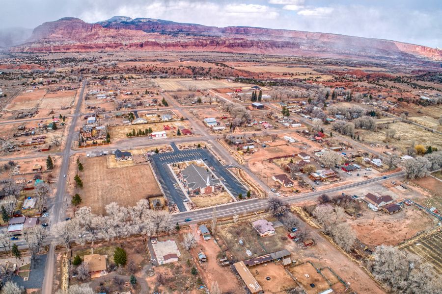 Aerial view of Torrey, Utah, nestled between red rock mesas and open desert terrain near Capitol Reef National Park.