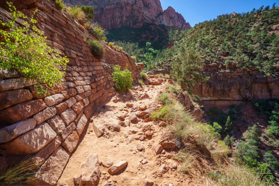 Historic dry stone retaining wall built along the Watchman Trail by the Civilian Conservation Corps, constructed from stacked native rock to stabilize the hillside.