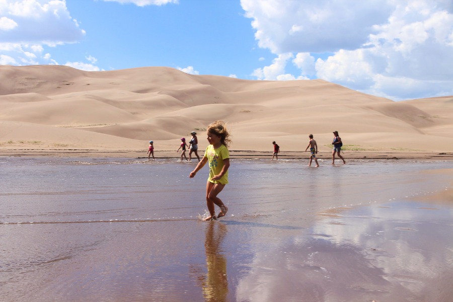 Visitors splashing in shallow water at Medano Creek.