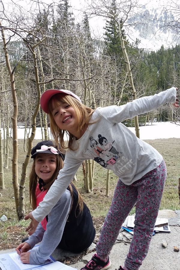Children working on Junior Ranger booklets at Wheeler Peak Campground with mountain views in the background.