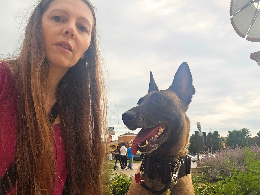 Female handler outside on an outing with her Malinois